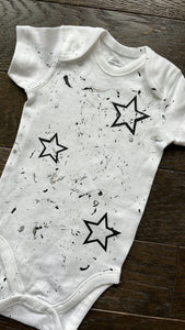 Black stars splatter paint onesie